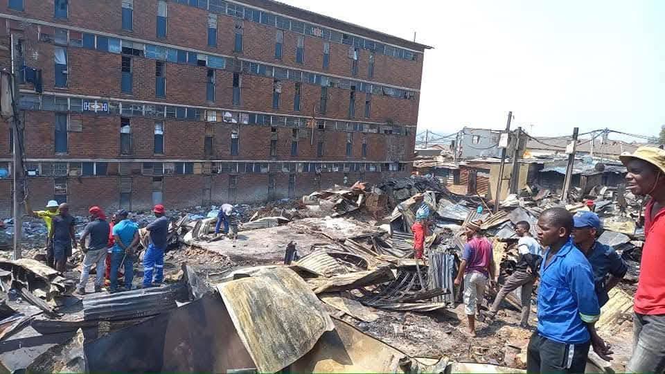 Firefighters at Madala Hostel in Alexandra after blaze guts top floor of the building, no injuries reported.