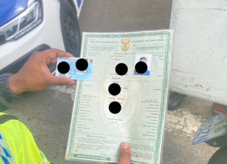 Durban Metro Police officers detaining delivery motorbikers during a law enforcement operation in Westville