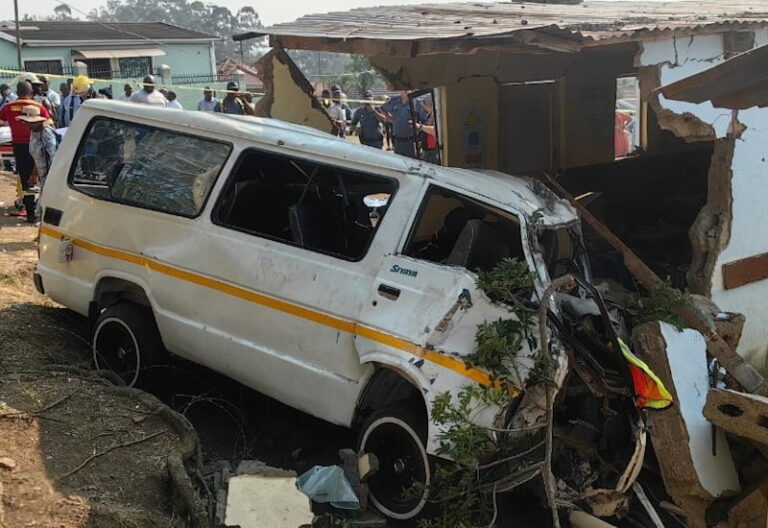 Crumpled minibus taxi after colliding with a creche building.